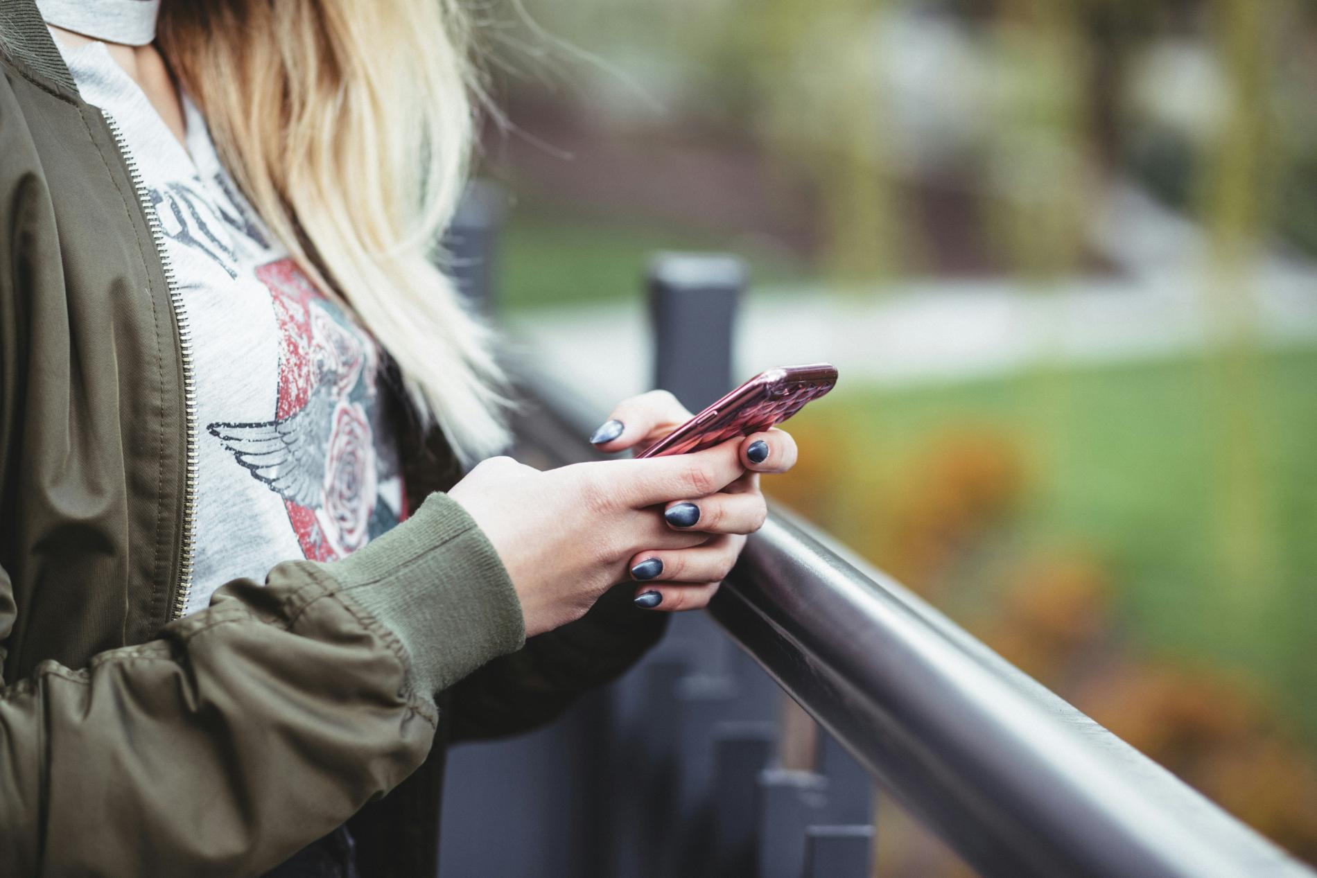 Woman holding her phone out in nature