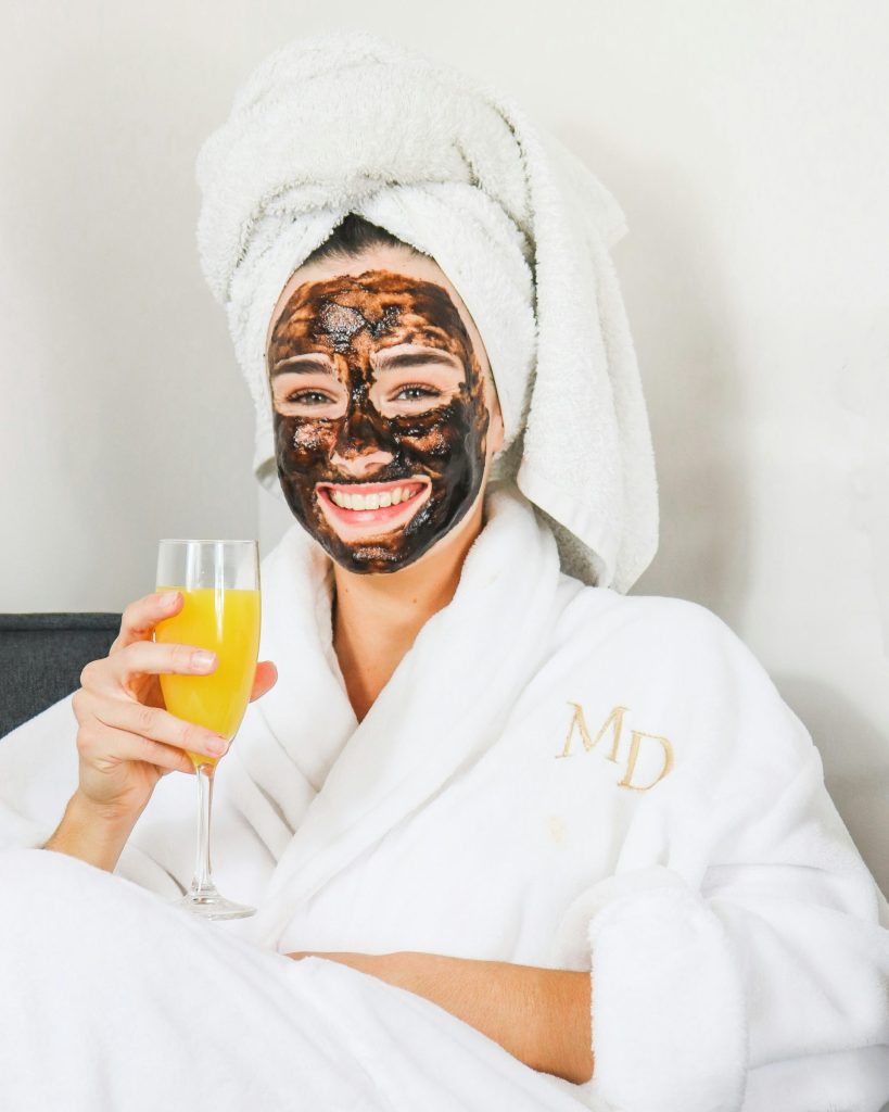 Woman who got a facial treatment sitting and drinking juice